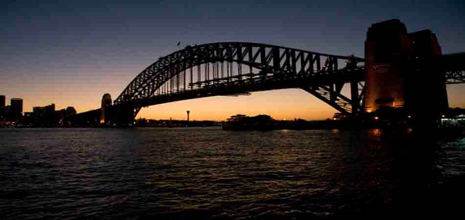 "A harbour bridge at sunset."